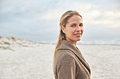 Portrait smiling blonde woman on winter beach