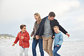 Playful family on winter beach