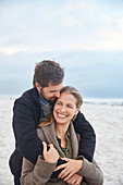 Smiling couple hugging on winter beach