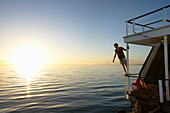 Man leaning on summer houseboat railing