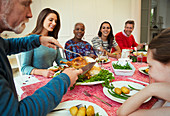 Family enjoying Christmas turkey dinner at table