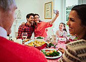 Couple taking selfie at Christmas dinner table