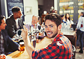 Portrait smiling bartender serving beer at bar
