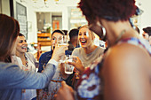 Enthusiastic women friends toasting wine glasses
