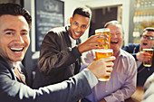 Men friends toasting beer glasses at bar