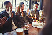 Friends cheering for woman celebrating birthday