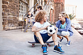 Smiling couple with soccer ball and skateboard