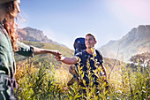 Young couple holding hands hiking in valley