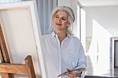 Smiling mature woman with palette painting
