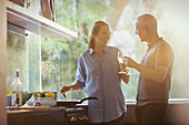 Couple toasting white wine glasses, cooking