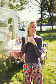 Smiling woman in pyjamas drinking coffee