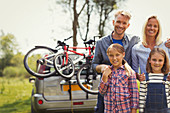 Portrait family near car with mountain bikes