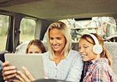 Mother and daughters watching video on tablet