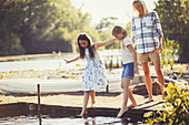 Mother watching daughters sticking toes in water