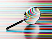 Magnifying glass leaning on striped background