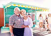 Portrait senior business owners outside food cart