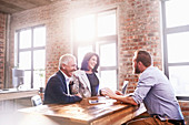 Smiling business people meeting at table in office