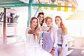 Young women taking selfie with business owner