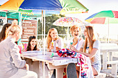 Happy women eating ice cream at picnic table