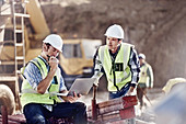 Foreman and construction worker using laptop