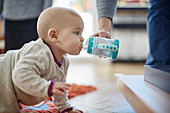 Baby girl crawling and drinking from sip cup