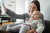 Smiling mother holding baby daughter