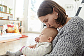 Mother kissing baby daughter on the head