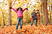 Playful girl throwing autumn leaves