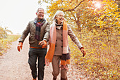 Senior couple holding hands walking on path