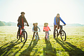 Portrait young family bike riding grass