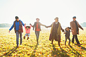 Playful family walking in autumn park grass