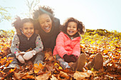 Portrait playful mother and daughters in leaves