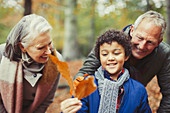Grandparents and grandson holding autumn leaf