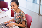 Portrait smiling college student using laptop