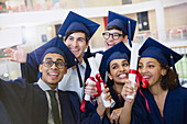 College students in cap and gown taking selfie