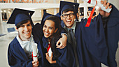 College graduates in cap and gown with diplomas