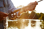 Close up senior man fly fishing at river