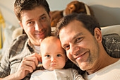 Portrait smiling male gay parents and baby son