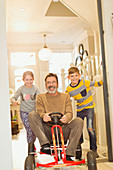 Children pushing father on toy car