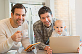 Portrait smiling male gay parents with baby