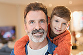 Close up portrait smiling father and son hugging