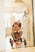 Playful male gay couple playing with toy car