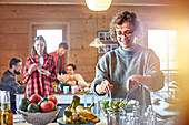 Woman tossing salad for friends in cabin