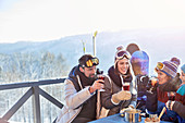 Snowboarder and skier friends drinking cocktails