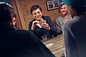 Friends playing cards at cabin table