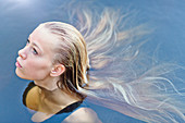 Blonde teenage girl with long hair floating