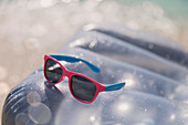 Sunglasses on inflatable lilo in water