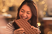 Woman craving biting into large chocolate bar