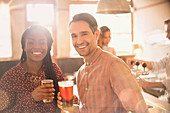 Portrait couple drinking beer in bar