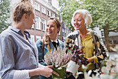 Florist showing plants to mother and daughter